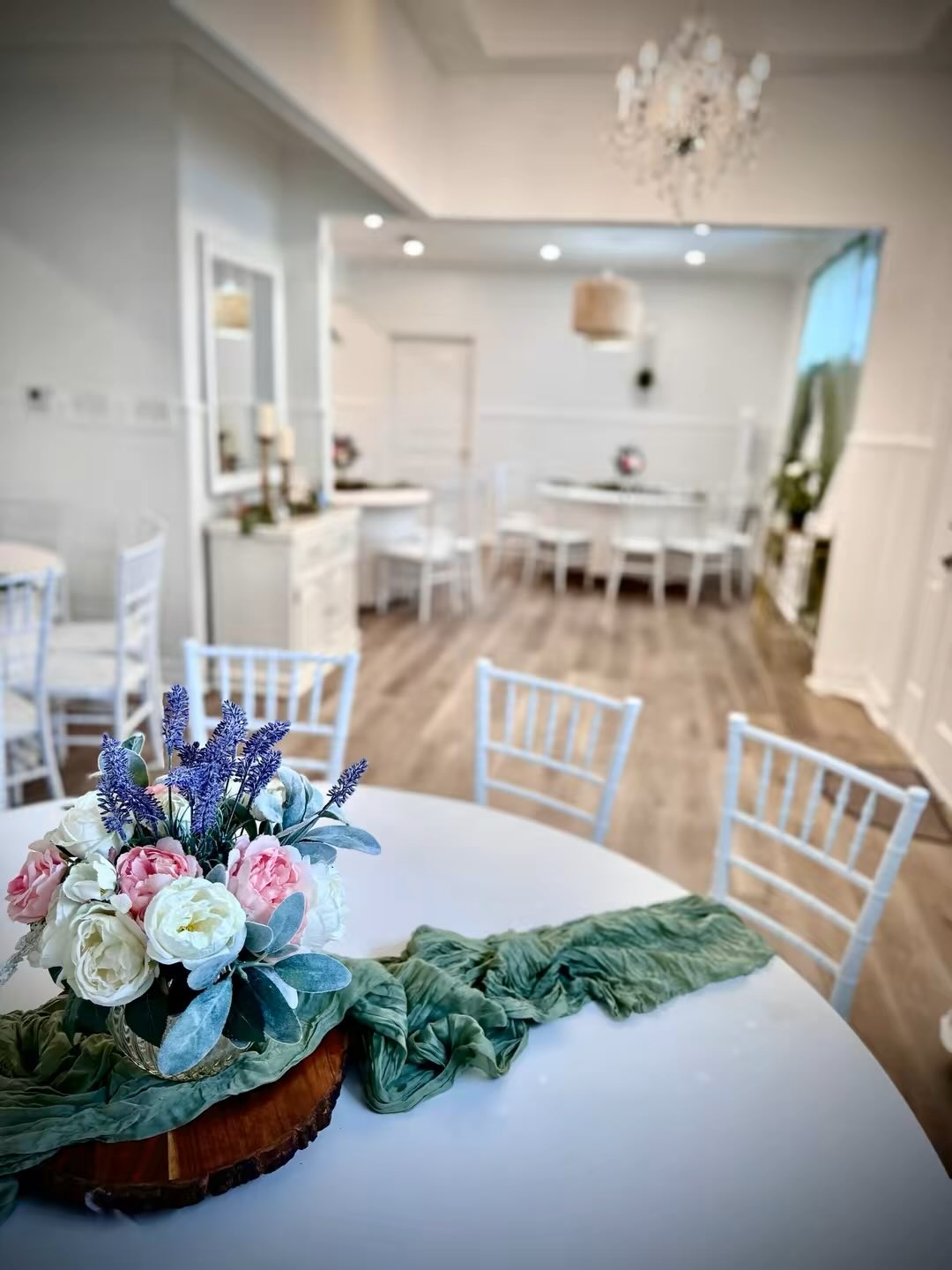 Decorated tables with floral centerpieces against a bright background